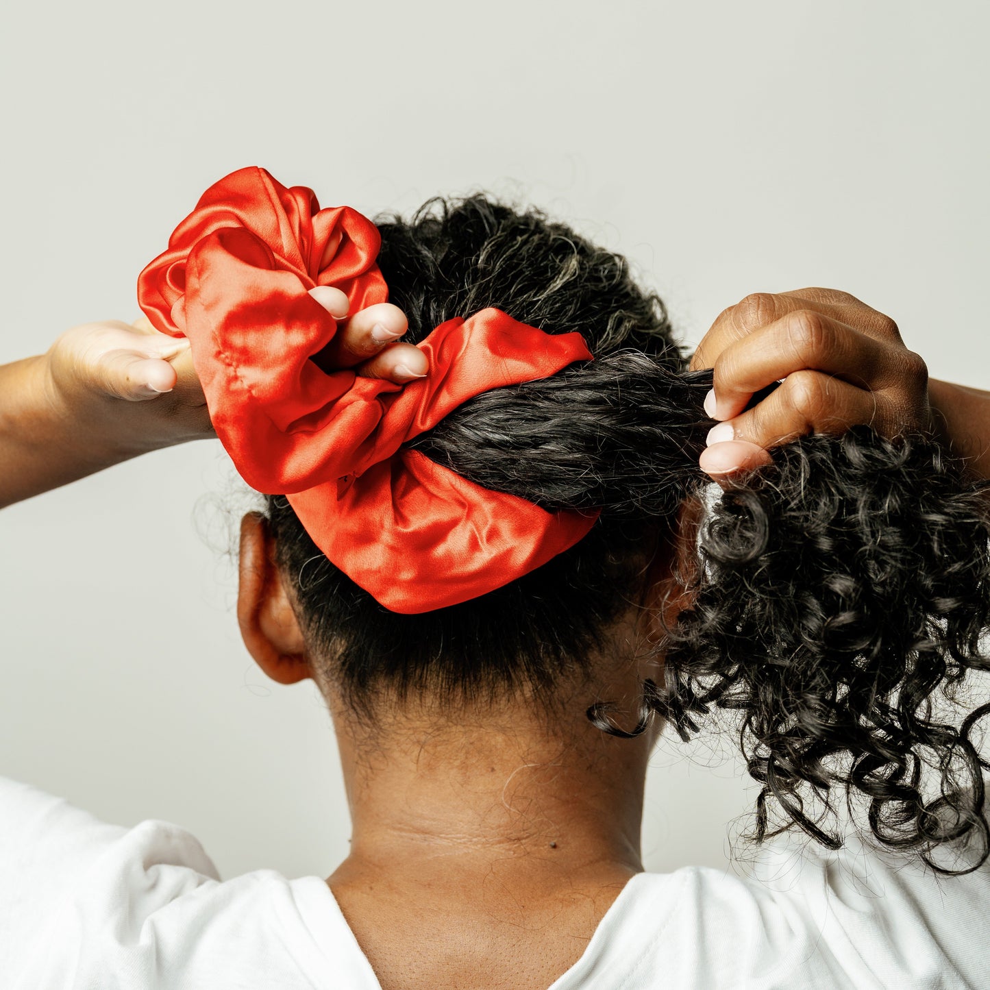 Organic silk oversized scrunchie in tomato red from LINA LENNOX, showing the soft, glossy fabric and relaxed fit.