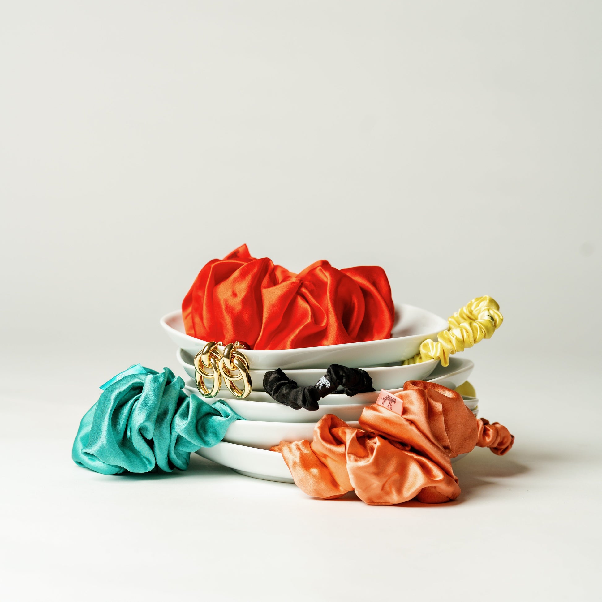 Organic silk oversized scrunchie in vibrant tomato red by LINA LENNOX, shown in close-up view.