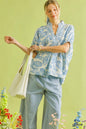 Light blue Umgee botanical print mixed trim tunic top with relaxed fit and stylish design, perfect for casual wear.