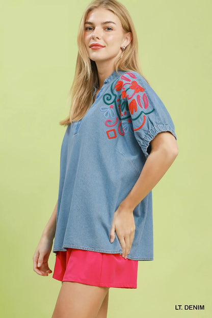 Light wash denim puff sleeve top with embroidery from Umgee, styled with a casual look.