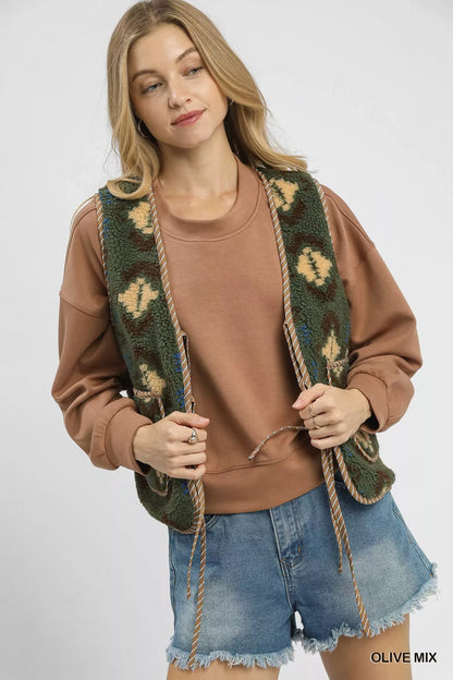 Olive green Umgee patterned Sherpa vest with tie front and mixed fabric design, styled for casual wear.