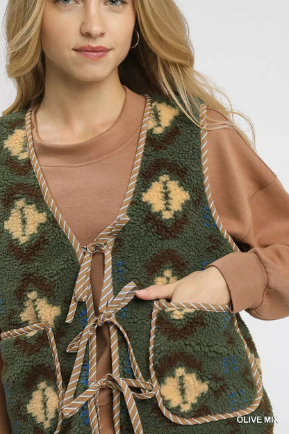 Olive green Umgee mix patterned sherpa tie-front vest with cozy collar and front tie, casual layered style for women.