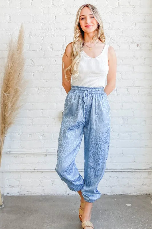 Pale blue satin leopard print joggers from And The Why by Trendsi, featuring a relaxed fit and stylish leopard pattern.