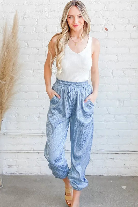 Pale blue satin leopard print joggers by Trendsi featuring a relaxed fit and stylish animal print design.
