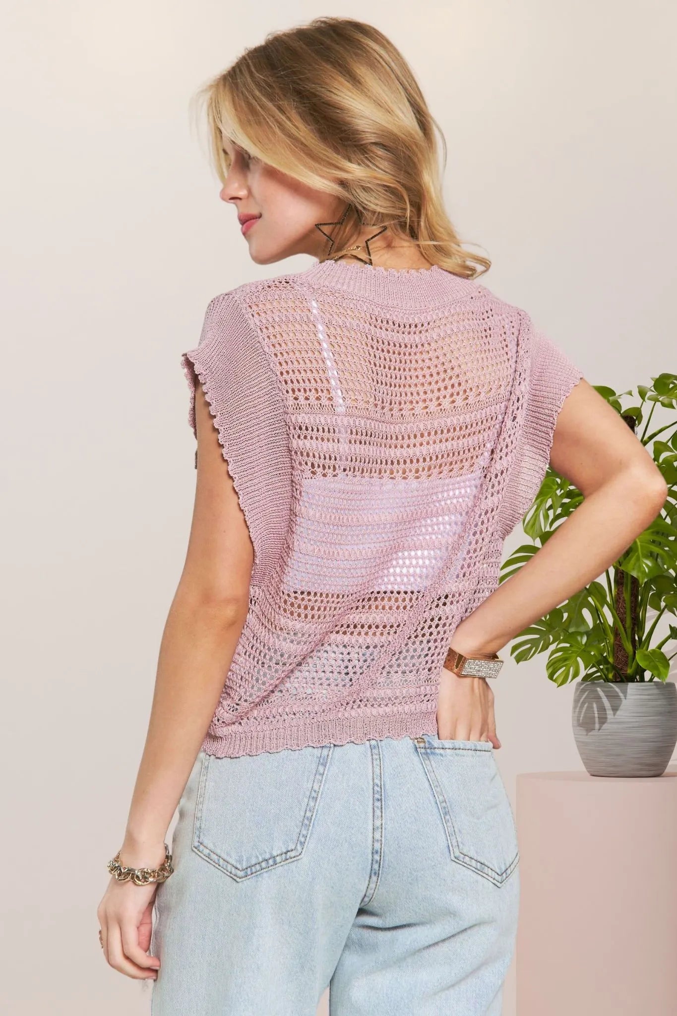 Pink crochet top by Trendsi with drawstring details, featuring a fitted sleeveless design and intricate knit pattern.
