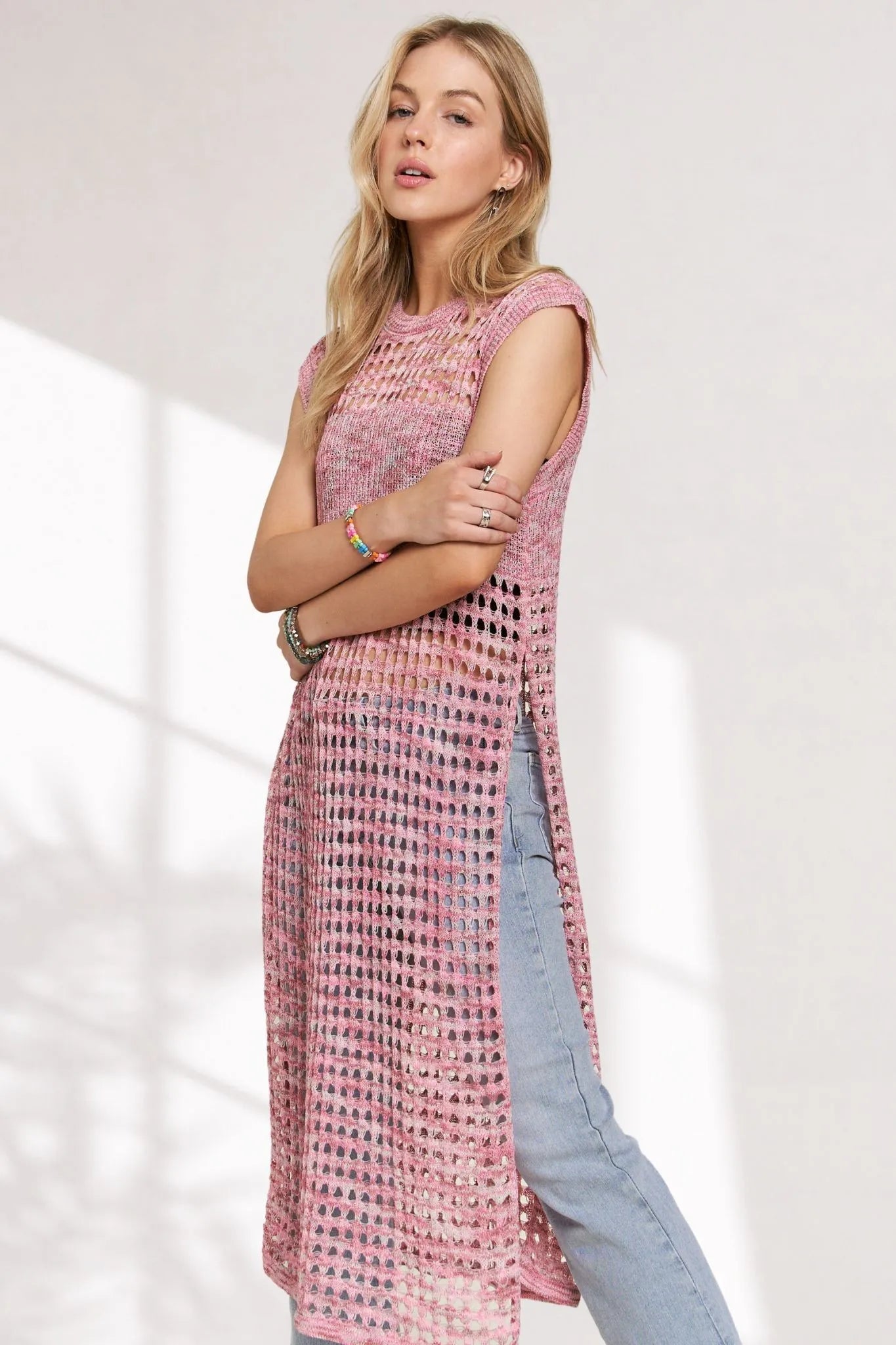 Pink multi-color crochet tunic top with long sleeves and relaxed fit, stylishly displayed on a hanger.