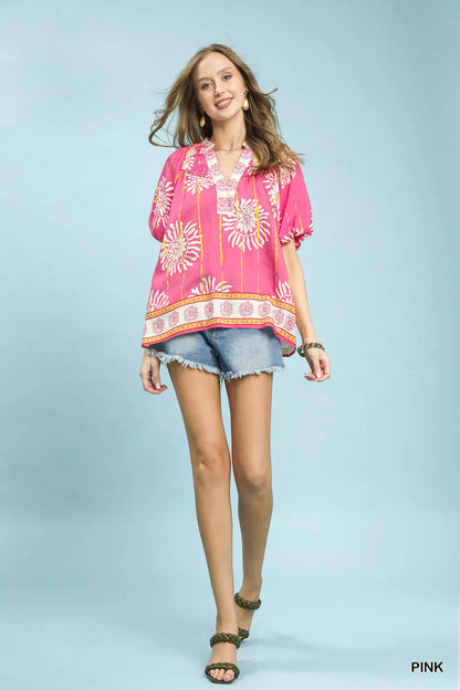 Pink Umgee floral border boho blouse with smocked V-neck and long sleeves, showcasing a stylish and flowy design.
