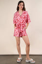 Pink oversized printed button-down resort romper by Very J, featuring a relaxed fit and stylish design.