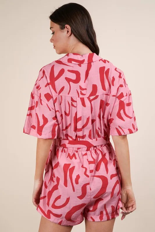 Pink oversized printed button-down resort romper by Very J, featuring a relaxed fit and stylish tropical-inspired design.