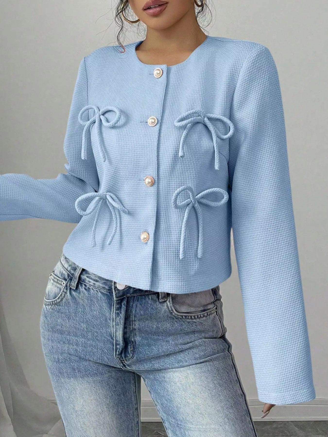 Apricot Bow Detail Cropped Outerwear by Trendsi, featuring a stylish cropped design with bow accents and textured fabric.