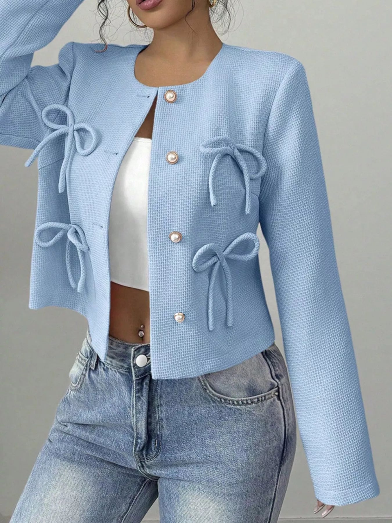 Apricot bow detail cropped outerwear by Trendsi, featuring a stylish bow accent on a lightweight, fashionable jacket.