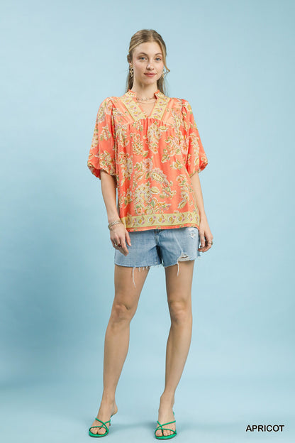 Umgee apricot floral boho blouse with long sleeves and ruffled details, featuring a relaxed fit and vibrant floral pattern.