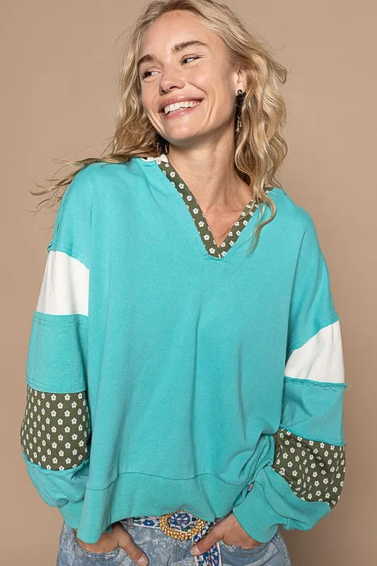 A blue POL Exposed Seam Floral Patchwork French Terry Hoodie with visible seams and floral patch accents, casual and comfortable style.