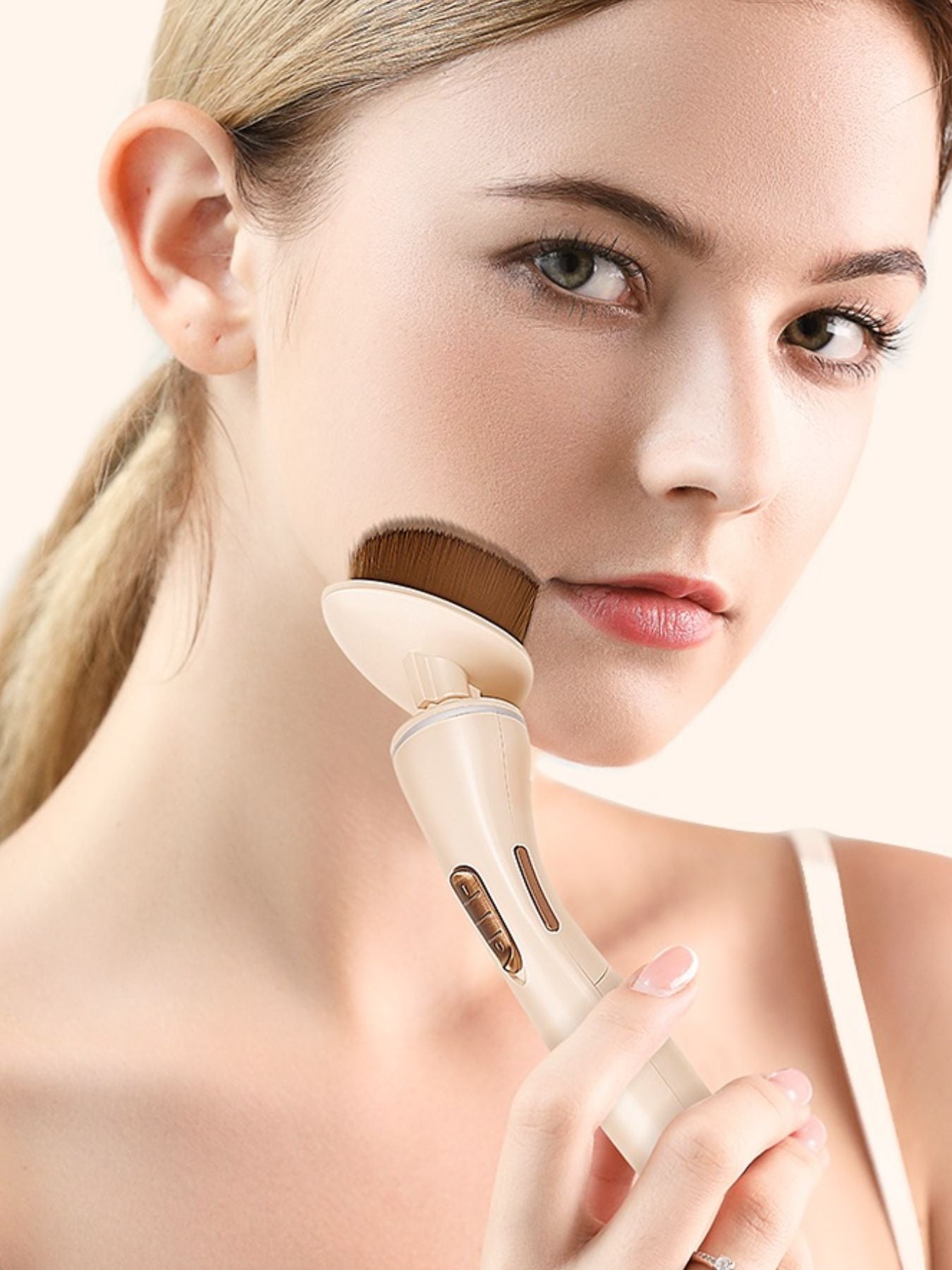 Beige electric makeup brush from Trendsi with sleek design, ideal for blending and applying makeup seamlessly.