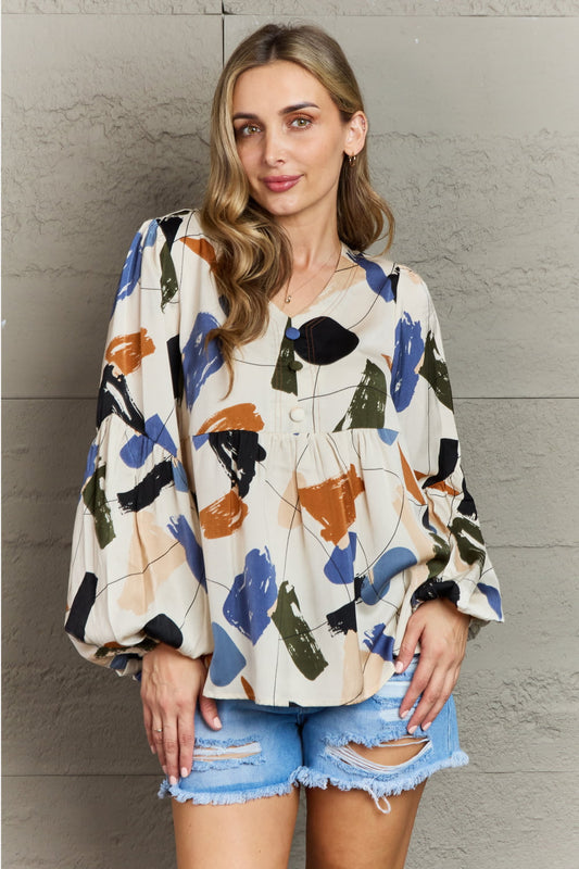 Multi-colored printed blouse by Hailey & Co, featuring a stylish design, worn by a model in a casual setting.
