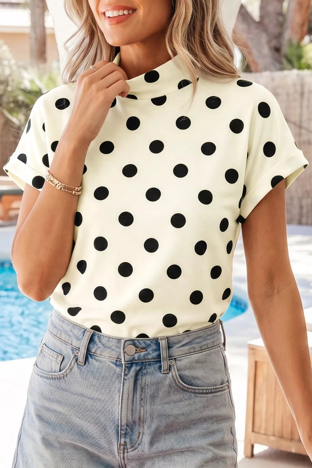 Beige polka dot mock neck short sleeve blouse by Trendsi, showcasing a stylish, lightweight top with a classic pattern and fitted design.