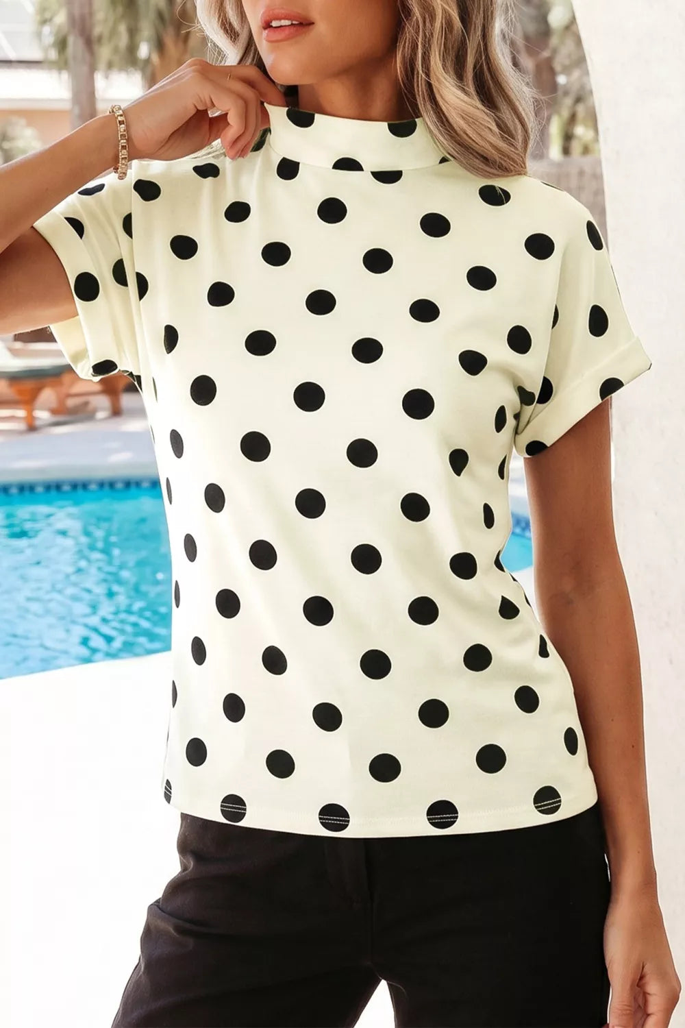 Beige polka dot mock neck short sleeve blouse by Trendsi, featuring a stylish mock neck and classic polka dot pattern.