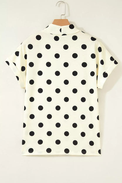 Beige polka dot mock neck short sleeve blouse by Trendsi, featuring a stylish design with a classic pattern and comfortable fit.