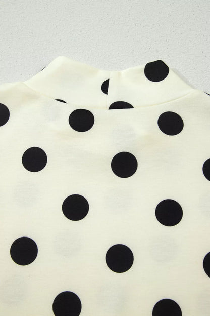 Beige polka dot mock neck short sleeve blouse by Trendsi featuring a stylish and comfortable design with a classic pattern.