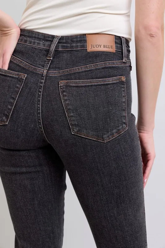 Trendy Judy Blue full-size mid-rise slim jeans with tummy control, designed for plus size women, showcasing fit and denim details.