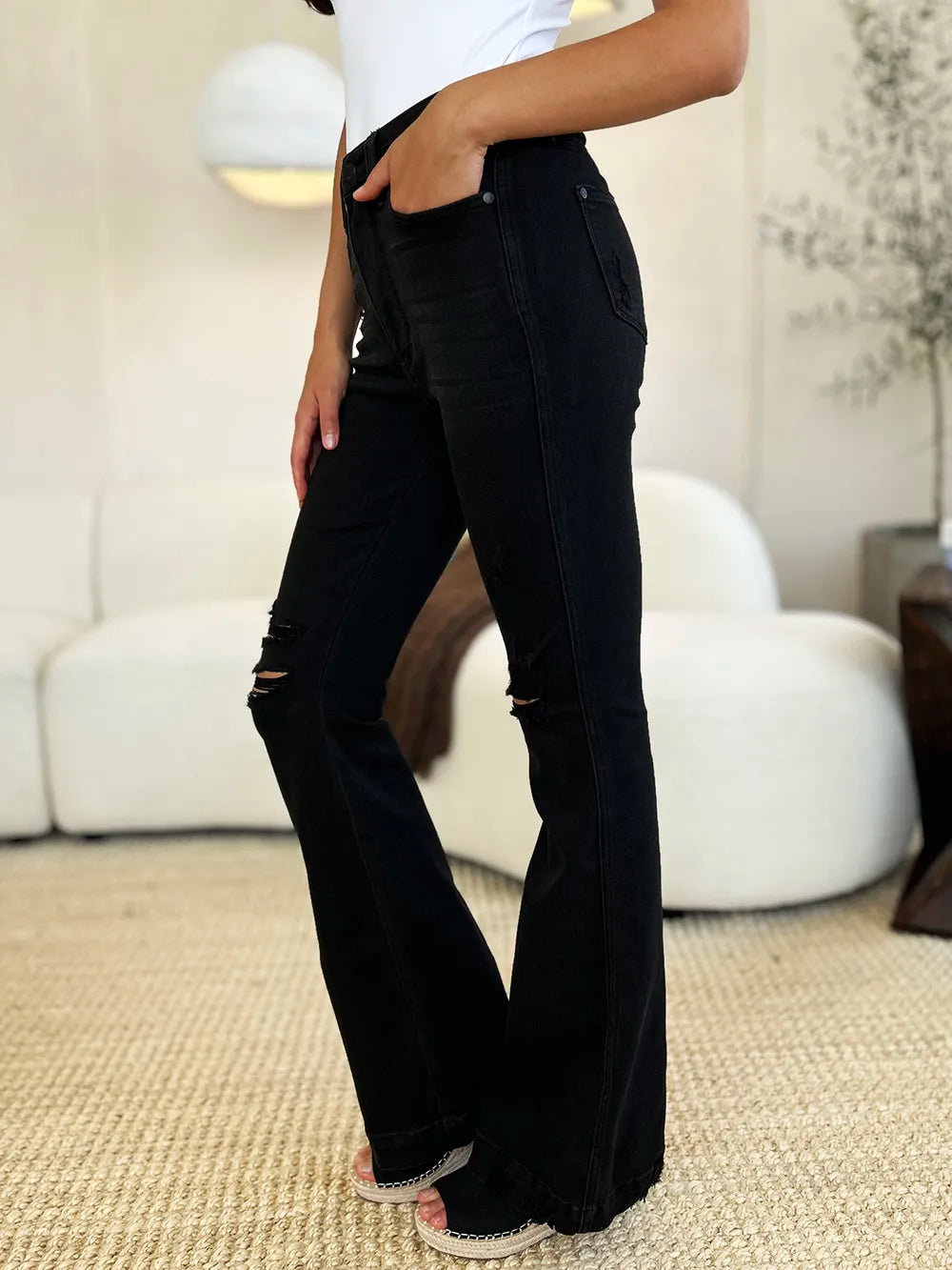 Black Judy Blue high waist distressed flare jeans, full size, showcasing a trendy fit with ripped detailing and flared leg style.