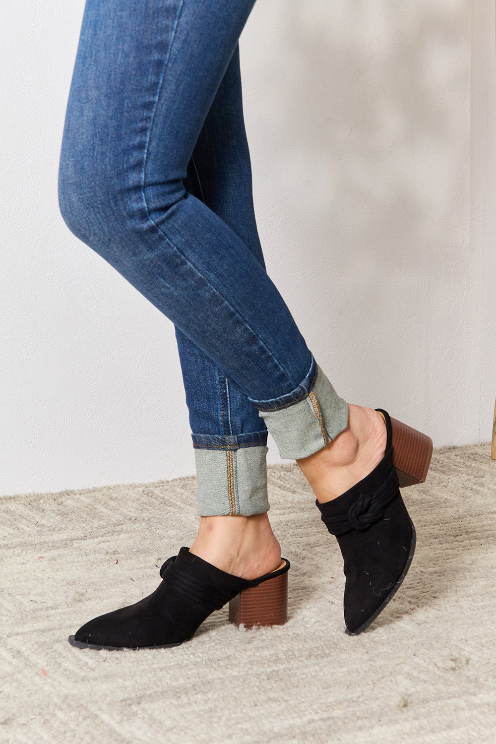 Black East Lion Corp pointed-toe braided trim mules with sleek design and stylish stitching, perfect for casual or dressy outfits.