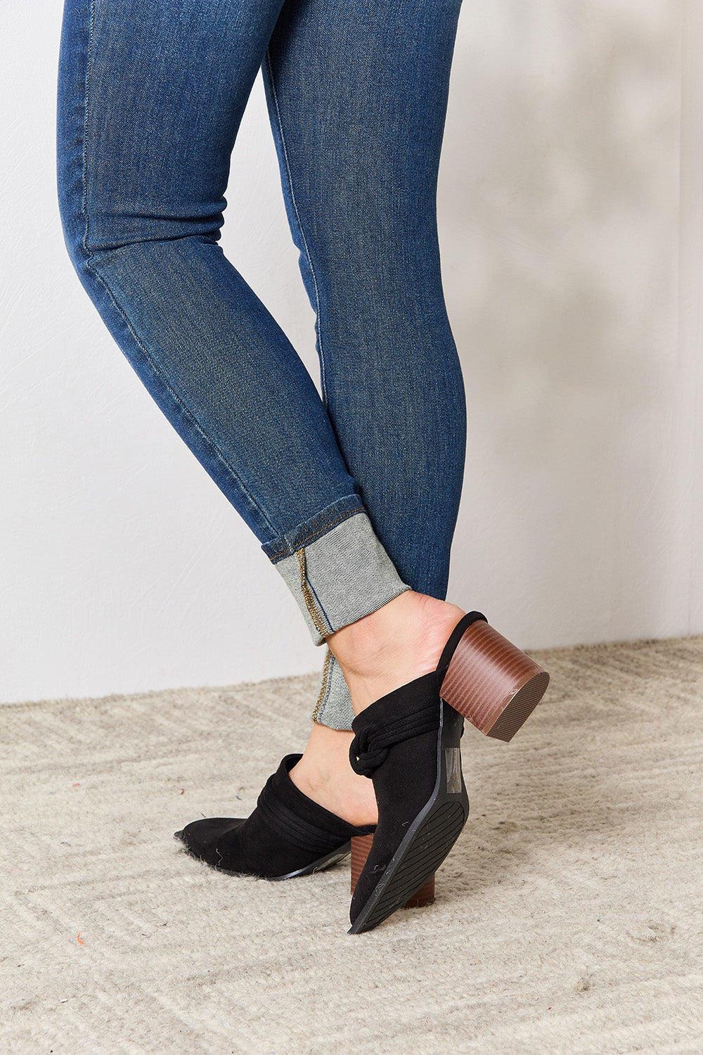 Black East Lion Corp pointed-toe braided trim mules with sleek design and low heel, stylish footwear for women.