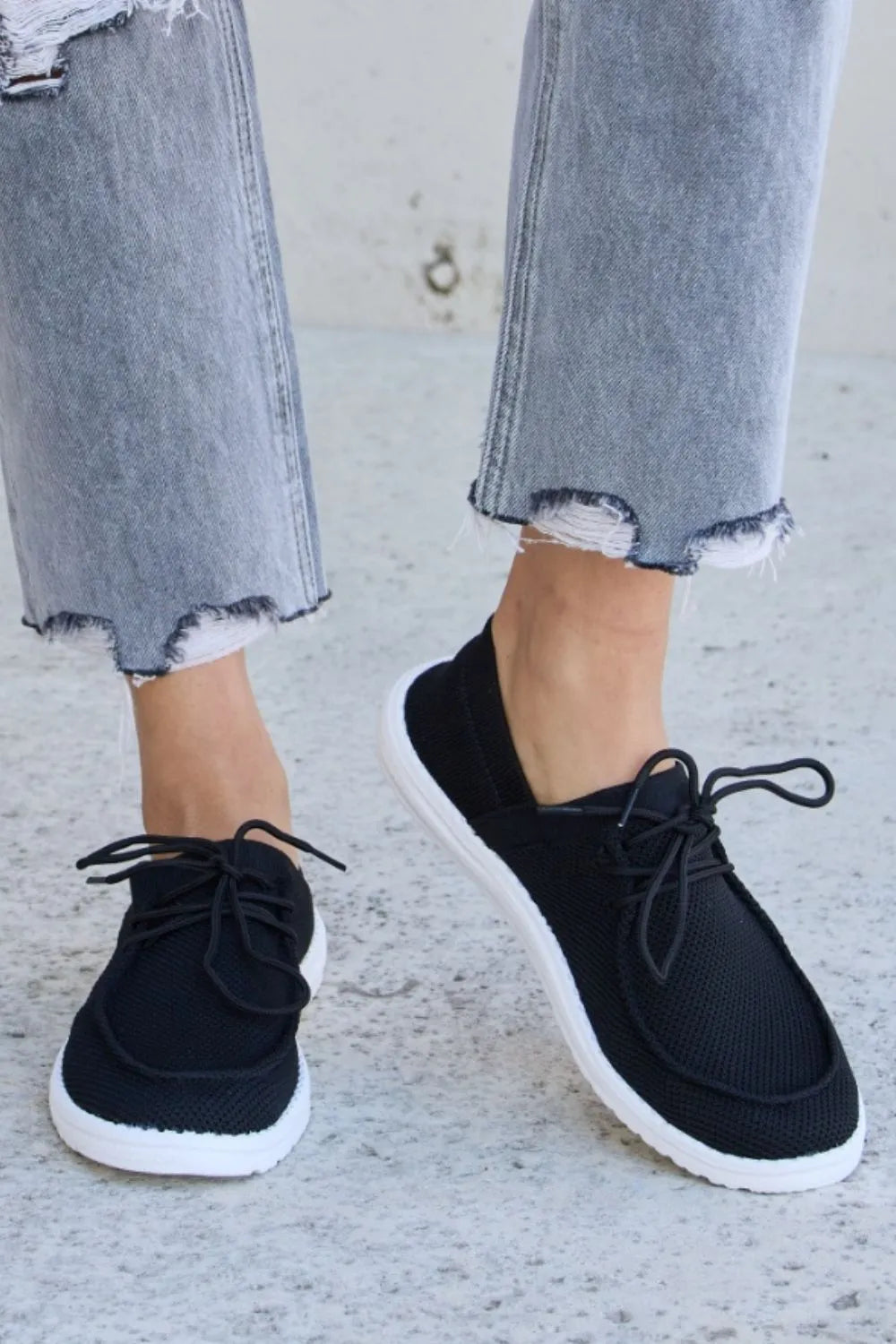 Black Forever Link flat round toe lace-up sneakers by Trendsi, featuring a sleek design and comfortable fit.