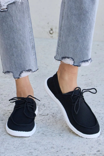 Black Forever Link flat round toe lace-up sneakers by Trendsi, featuring a sleek design and comfortable fit.
