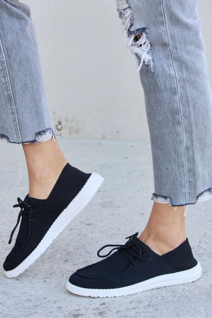 Black Forever Link flat round toe lace-up sneakers by Trendsi featuring a sleek design and comfortable fit.