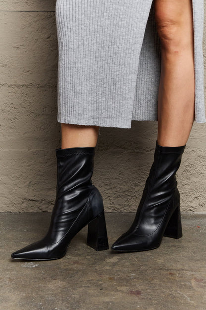 Black Weeboo Stacy block heel sock boots by Trendsi with a sleek design and comfortable fit, shown on a model.
