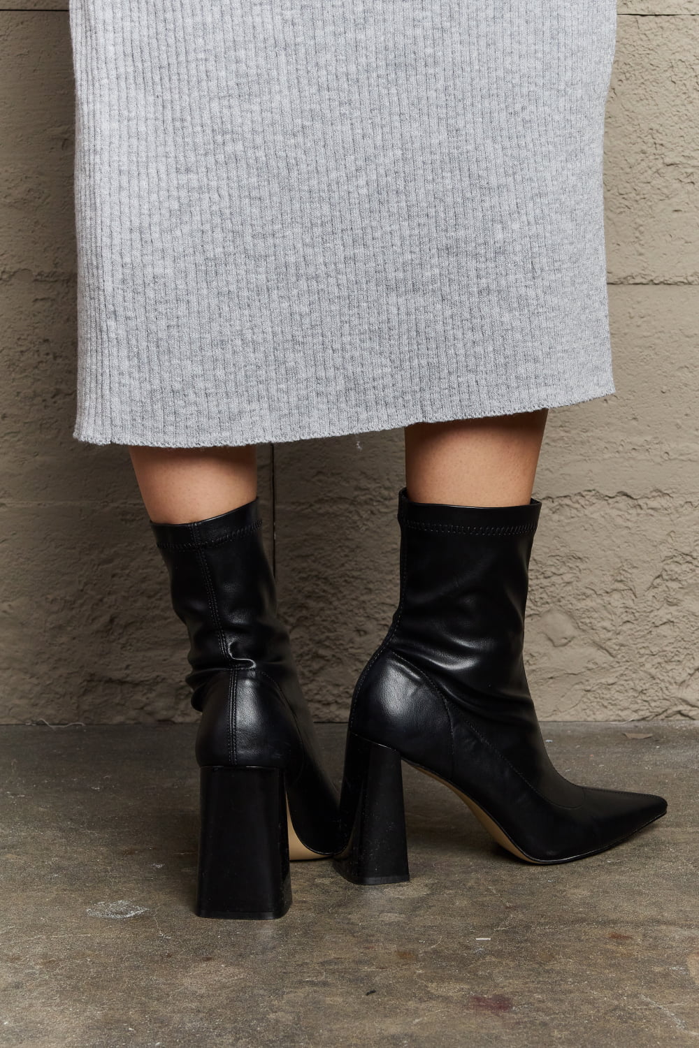 Black Weeboo Stacy block heel sock boots by Trendsi, showcasing sleek design and comfortable fit with a stylish heel.