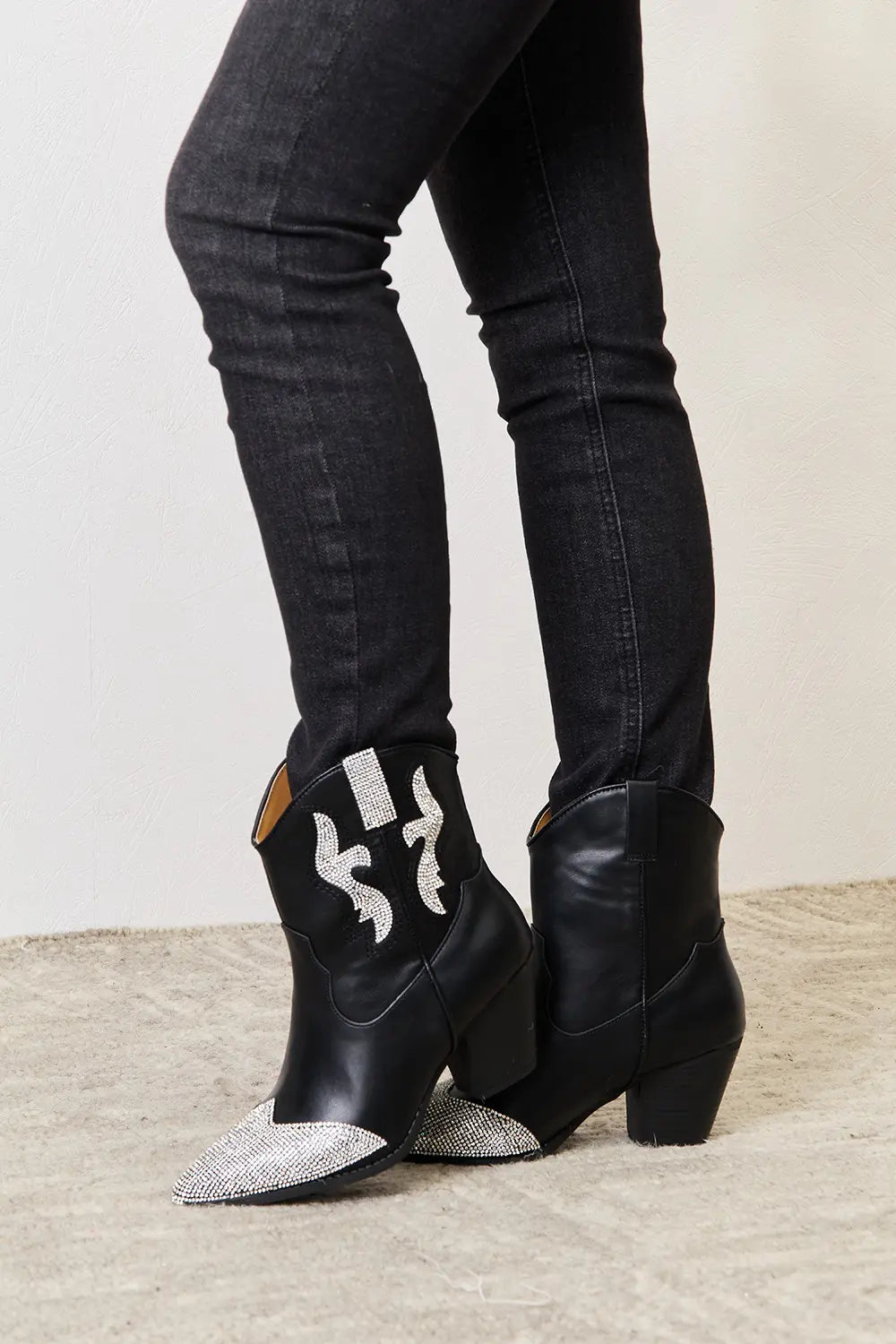 Black rhinestone pointed boots by East Lion Corp featuring a sleek design and sparkling embellishments.