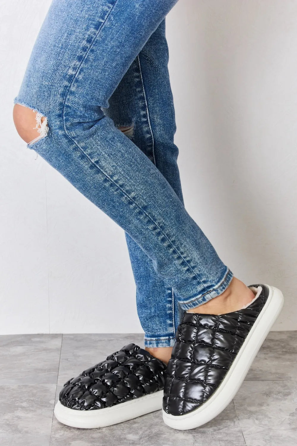 Black Melody Puffer Plush Slippers by Trendsi featuring a cozy, padded design and soft plush material for comfortable indoor wear.