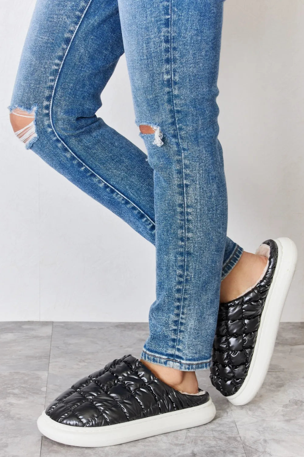 Black Melody Puffer Plush Slippers by Trendsi featuring a cozy, padded design and slip-on style for comfortable indoor wear.