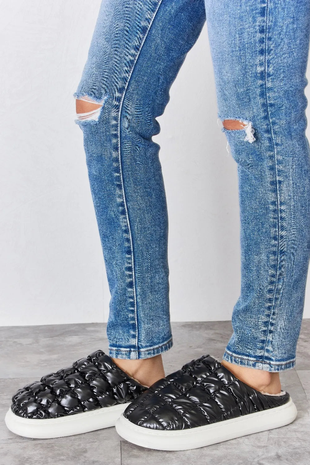 Black Melody Puffer Plush Slippers by Trendsi featuring cozy, padded design and soft plush material for comfortable indoor wear.