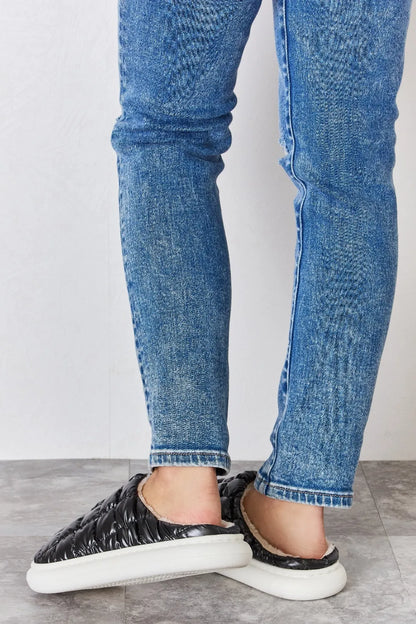 Black Melody Puffer Plush Slippers by Trendsi featuring a cozy, quilted design and soft plush material for comfortable indoor wear.