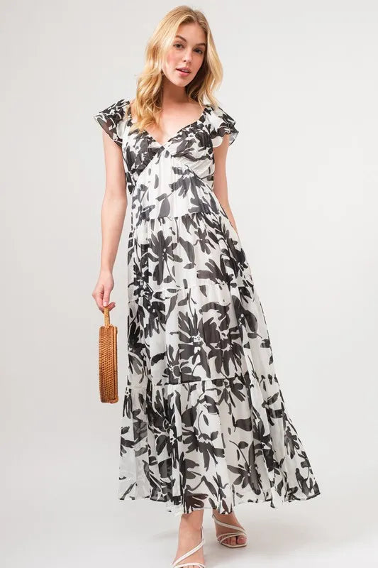 Black and cream floral print maxi dress with ruffled sleeves and tiered design from the And The Why collection by Trendsi.