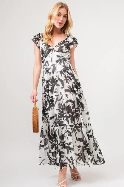 Black and cream floral print maxi dress with ruffled sleeves and tiered design from the And The Why collection by Trendsi.