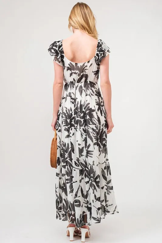 Black and cream floral print maxi dress with ruffled sleeves and tiered design from Trendsi's And The Why collection.