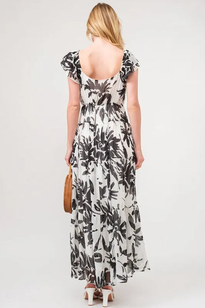Black and cream floral print maxi dress with ruffled sleeves and tiered design from Trendsi's And The Why collection.