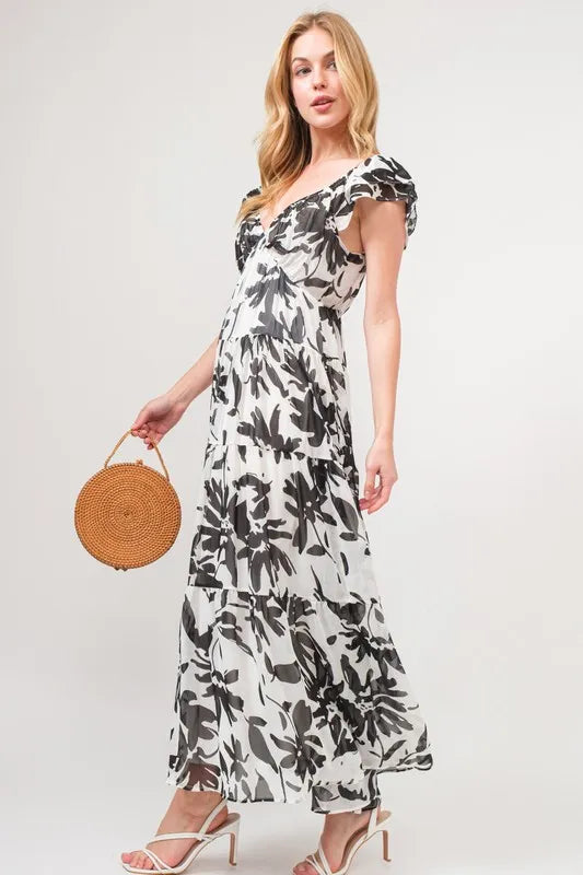 Black and cream floral print maxi dress with ruffled sleeves and tiered design from Trendsi's And The Why collection