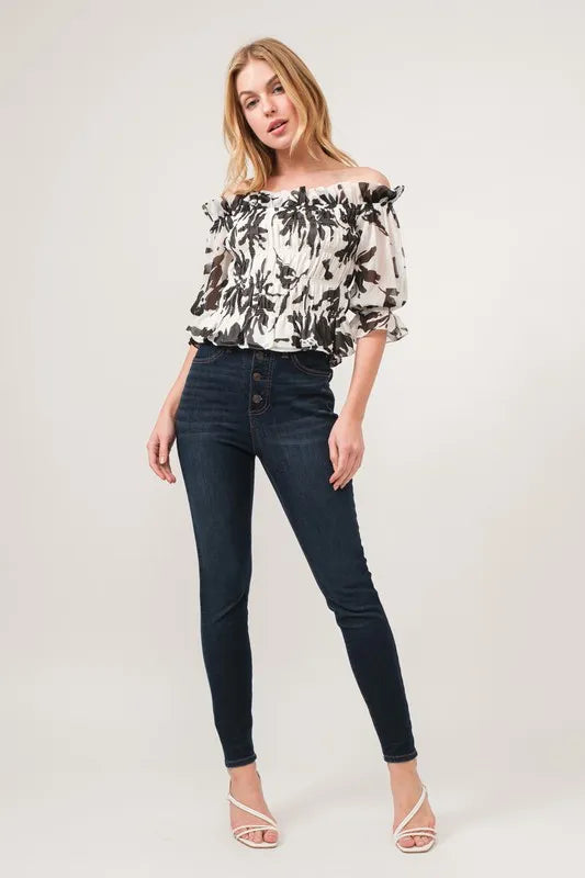 Black and cream floral printed smocked off-shoulder top by Trendsi, featuring a feminine off-shoulder design and floral pattern.