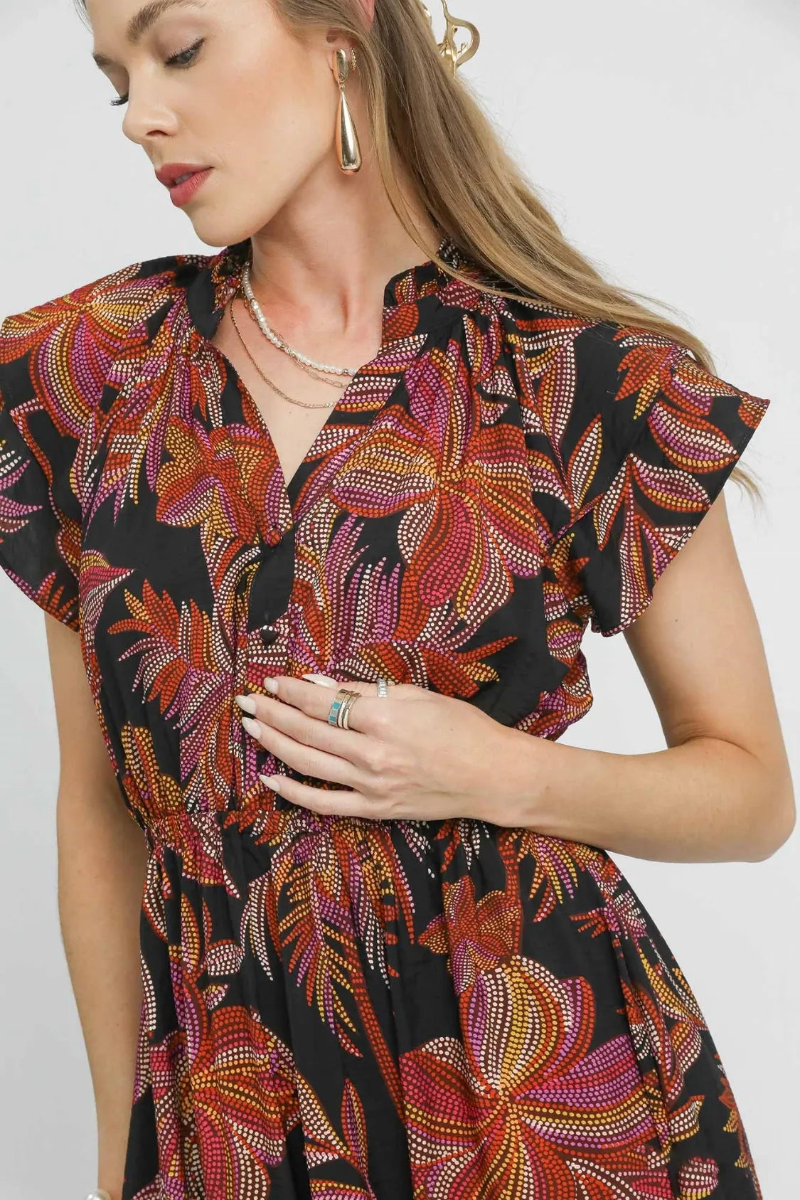 Black Umgee tropical midi dress with ruffle sleeves, featuring a mix of patterns and a relaxed, flowy silhouette.