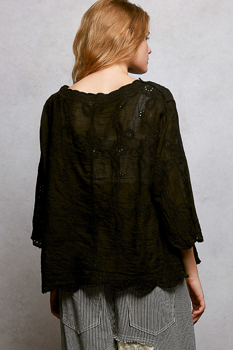 Black floral eyelet V-neck shirt with scalloped hem, featuring a relaxed fit and trendy design by Trendsi.