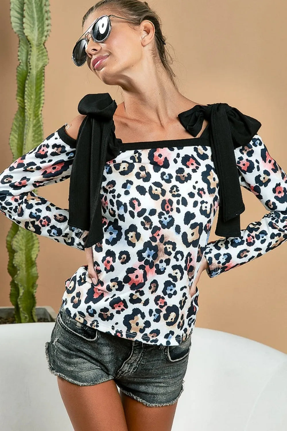 Black leopard print long sleeve top with shoulder tie detail from BiBi by Trendsi, featuring a stylish and comfortable design.