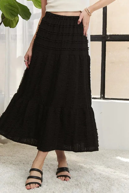 Black ADORA elastic waistband tiered midi skirt by Trendsi, featuring a flowy, layered design perfect for casual or dressy looks.