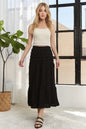 Black ADORA tiered midi skirt with elastic waistband, flowing layered design, ideal for casual or semi-formal outfits.