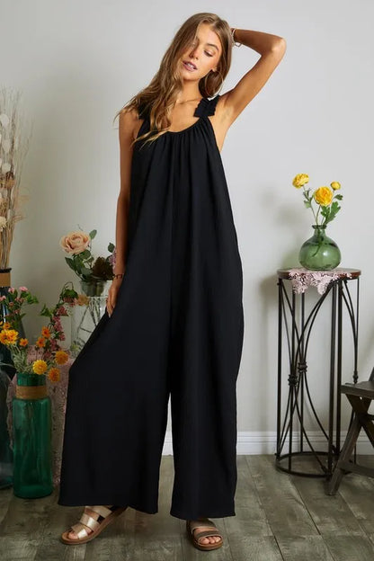 Black plus size ADORA jumpsuit by Trendsi featuring elastic ruffle shoulder straps and a full-length design.