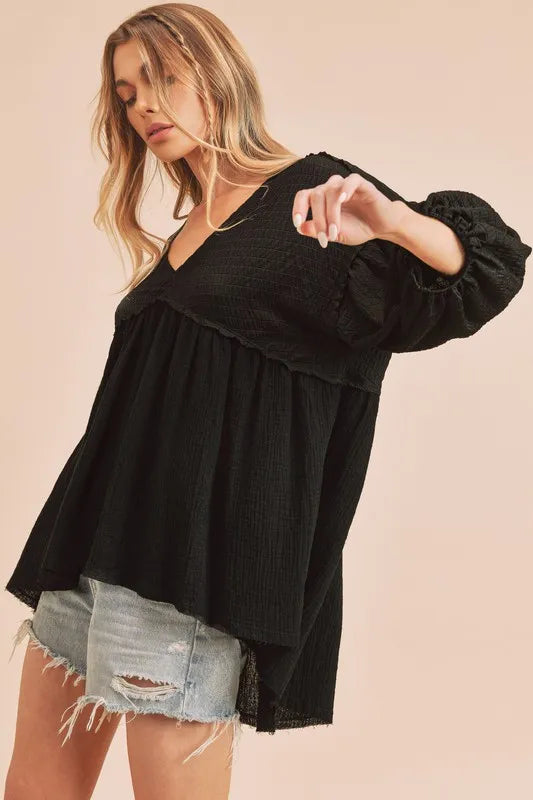 Black Aemi + Co high-low V-neck blouse with frayed hem, stylish and flowy women's top for casual or dressy occasions.